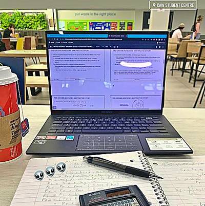 Laptop và vở ghi trên bàn.