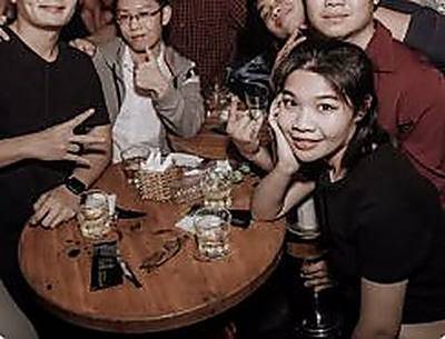 Một bàn bạn bè ngồi kín quanh nhau.